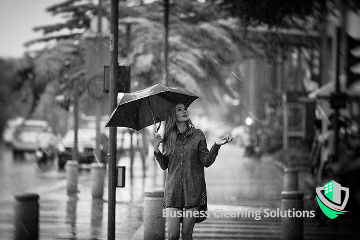A woman caught in the rain with umbrella