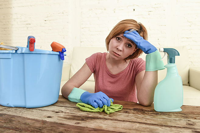 A frustrated businesswoman is tired of cleaning.