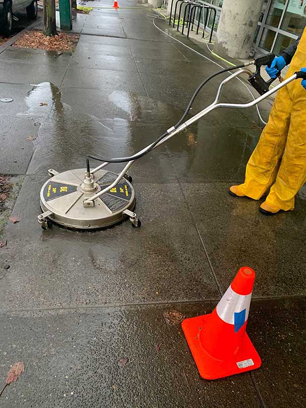 concrete scrubbing machine cleans a sidewalks.