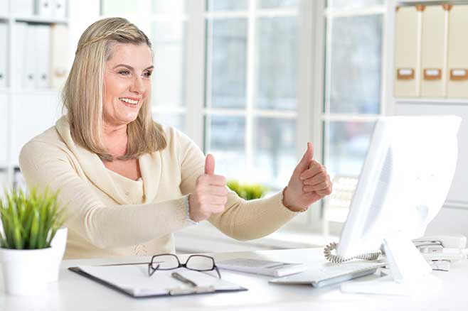 Happy professional at her desk communicating with her commercial cleaning company.