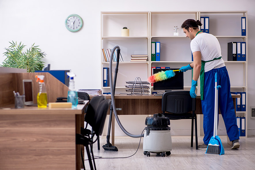 Commercial cleaner dusts an office following the detail day cleaning schedule.