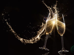 two champaign flutes in a celebratory cheer spilling champaign
