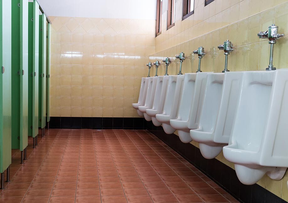 Clean men's restroom in manufacturing facility