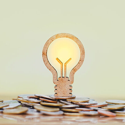 A light bulb is illuminated over money good money saving idea